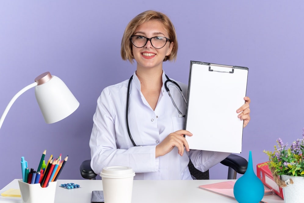 une secrétaire médicale souriante présentent un formulaire .