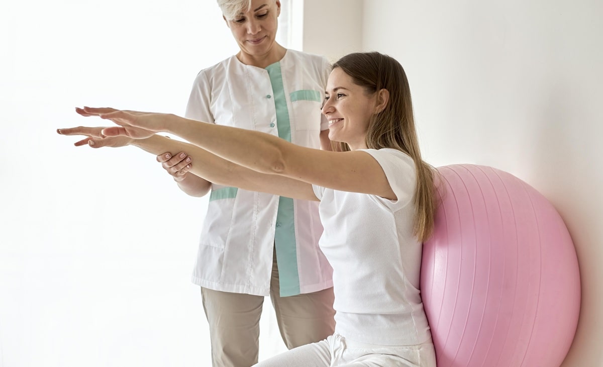 une kinésithérapeute avec une patiente en plein exercice de rééducation.