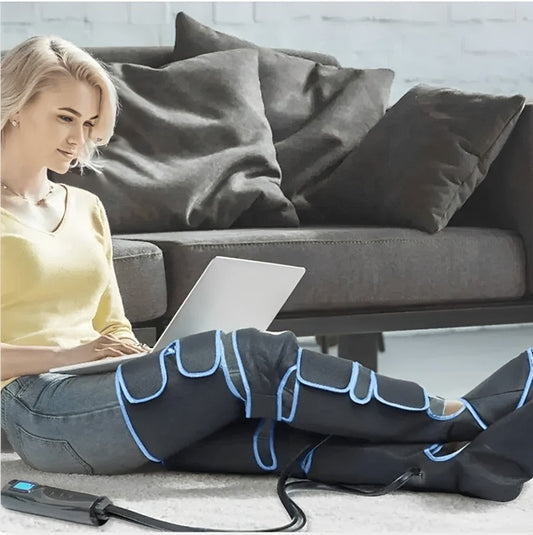 une femme travaillant sur son ordinateur avec les botes de pressothérapie sur les jambes