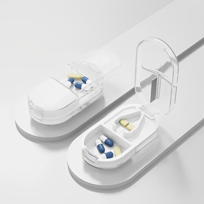 Coupe comprimé pilulier "MediCut Pro" de couleur blanc transparent posé sur une barre grise sur fond blnc