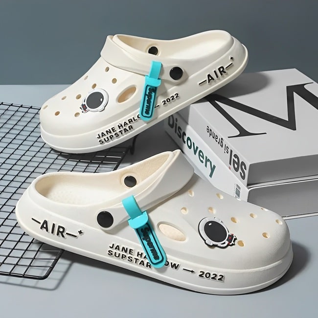 Sabots UltraLight Santé Mr Bon Plan, avec un design respirant et léger, pour un confort prolongé et un style moderne adapté aux professionnels de la santé. De couleur blanche avec pin's astronaute .