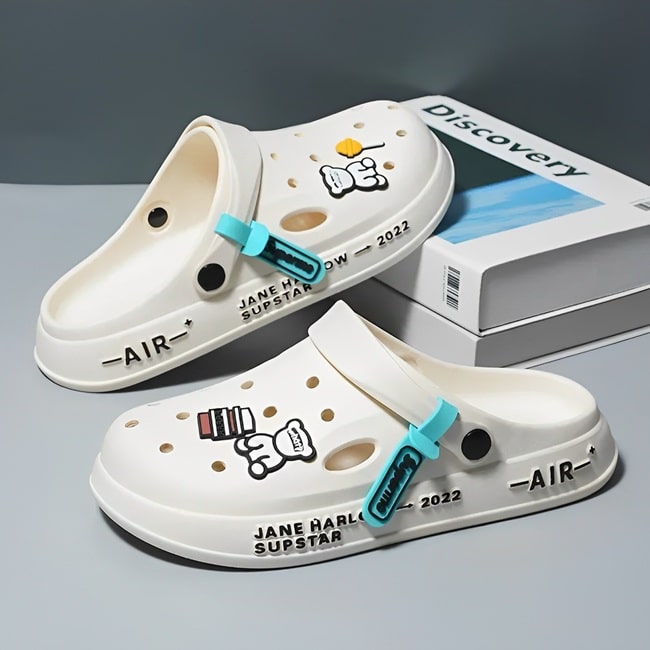 Sabots UltraLight Santé Mr Bon Plan, avec un design respirant et léger, pour un confort prolongé et un style moderne adapté aux professionnels de la santé. De couleur blanche avec pin's de petit ours et friandises .