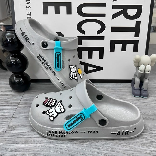 Sabots UltraLight Santé Mr Bon Plan, avec un design respirant et léger, pour un confort prolongé et un style moderne adapté aux professionnels de la santé. De couleur grise avec pin's petit ours et friandises .