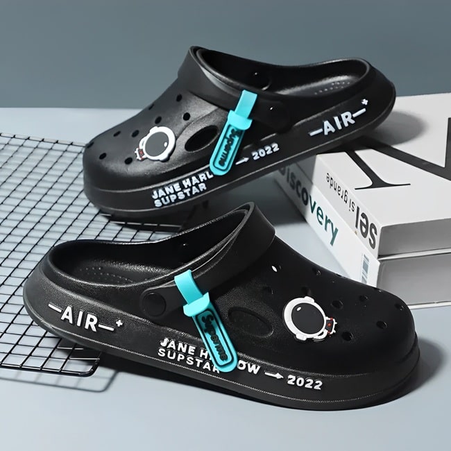 Sabots UltraLight Santé Mr Bon Plan, avec un design respirant et léger, pour un confort prolongé et un style moderne adapté aux professionnels de la santé. De couleur noire avec pin's astronaute .