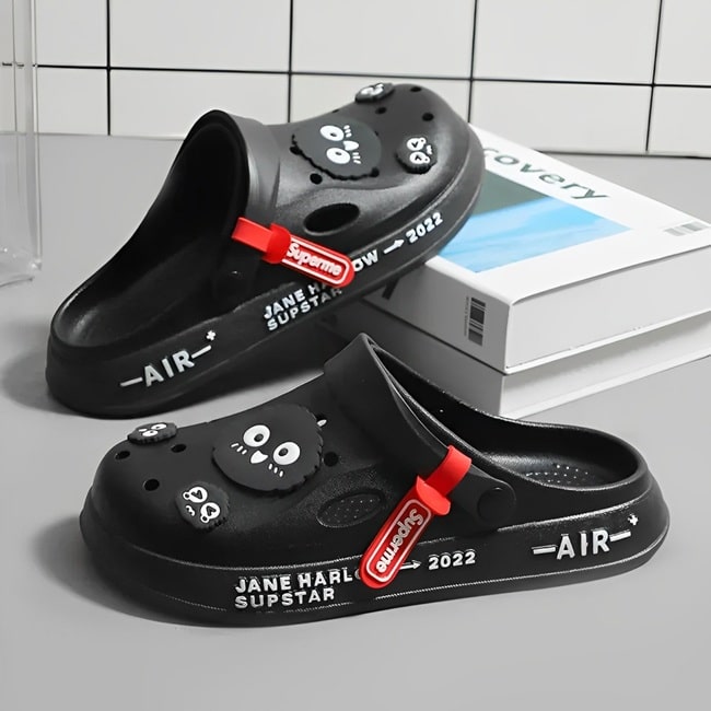 Sabots UltraLight Santé Mr Bon Plan, avec un design respirant et léger, pour un confort prolongé et un style moderne adapté aux professionnels de la santé. De couleur noire avec pin's oiseaux .