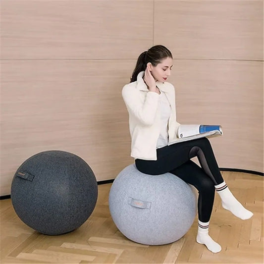 un femme assise sur une swiss ball dans sa housse d'habillage gris claire a cote d'une swiss ball dans sa housse d'habillage gris