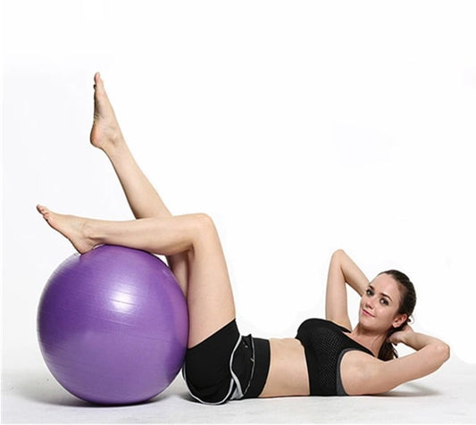 femme allongé sur le dos avec une swiss ball sous les genou