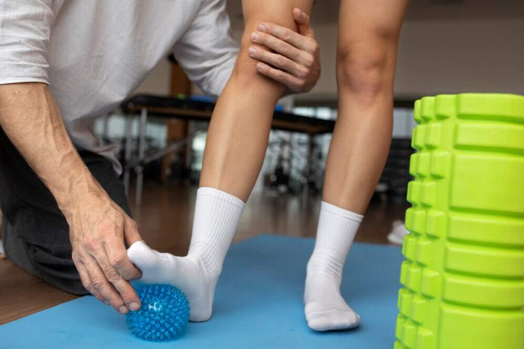 un patient utilisant une balle de rééducation orthopédique et un rouleau de travail musculaire massant