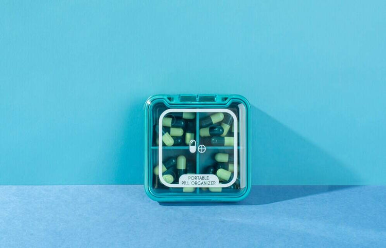 un pilulier remplis de médicaments poser sur un meuble 