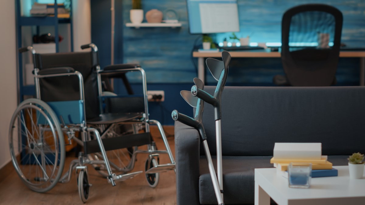 un fauteuil roulant et des béquilles dans le salon d'un particulier en convalescence