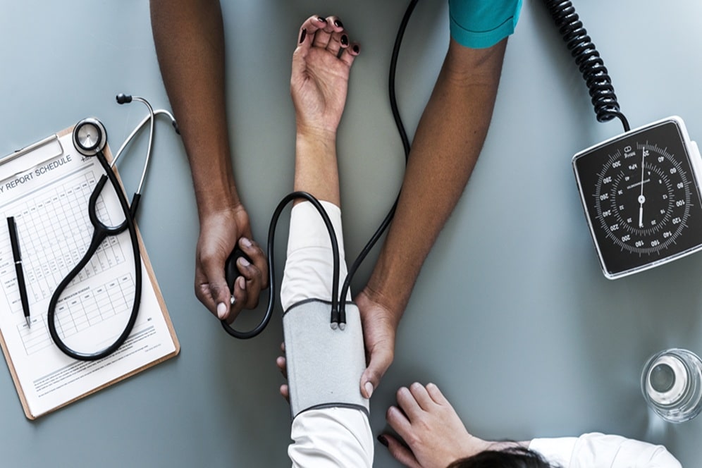 un medecin prenant diferente mesur sur son patient avec un stéthoscope et un tensiomètre.