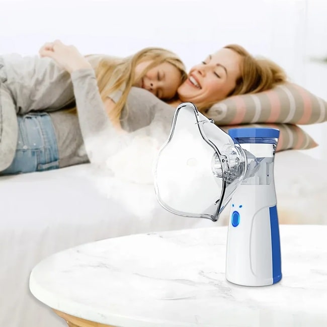 un nebulisateur posé sur une table avec en arrière plan un enfant qui fait un câlin a sa maman alongé sur le canapé